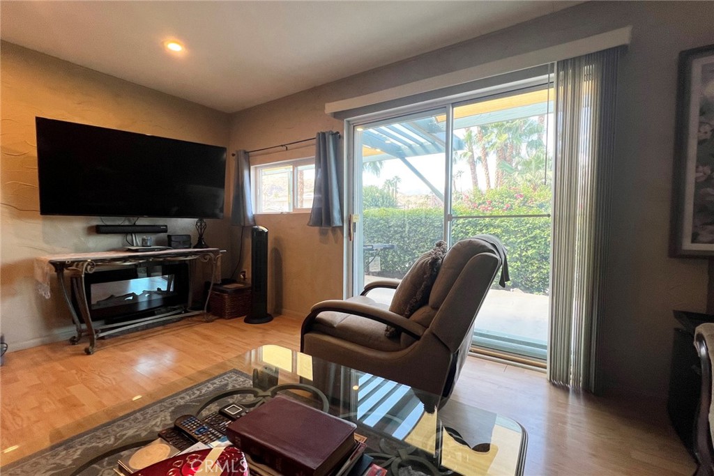 119 Del Mar Rancho Mirage, CA 92270 - Photo 14 of 40 a living room with furniture a flat screen tv and a floor to ceiling window