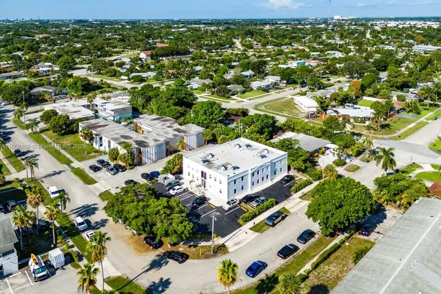 an aerial view of residential houses with outdoor space and a lake view