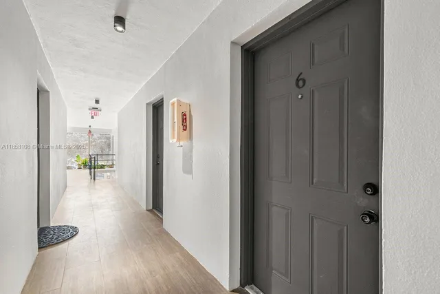 a view of hallway with livingroom and wooden floor