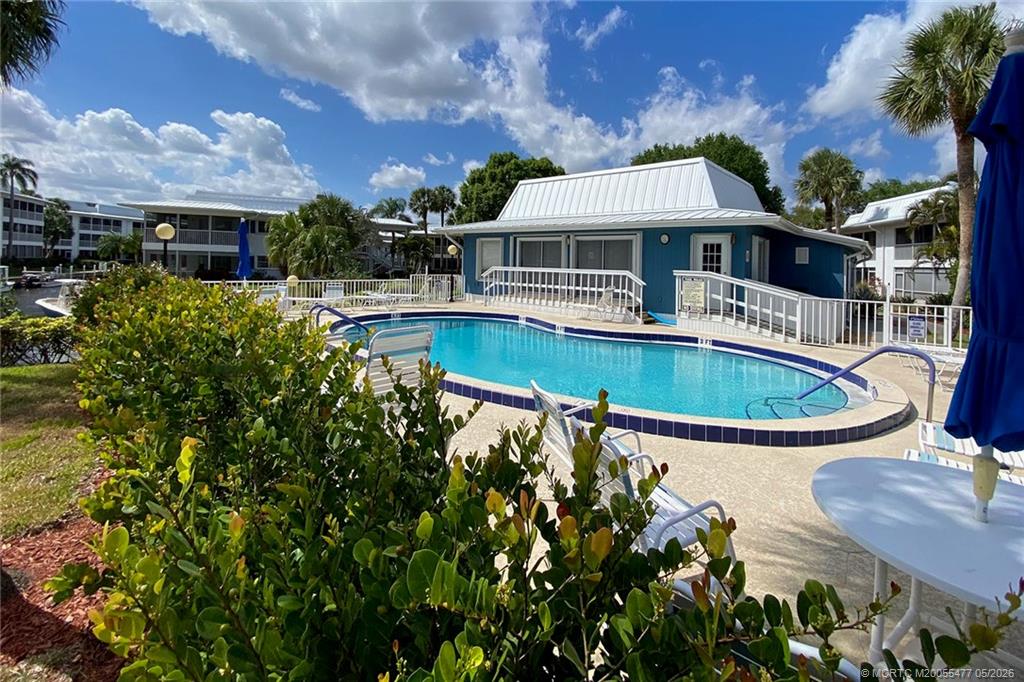 1852 Southwest Palm City Road, Unit 201 Stuart, FL 34994 - Photo 29 of 34 a front view of house with a garden and swimming pool