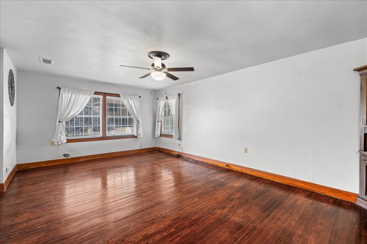 1107 Washington Street Brenham, TX 77833 - Photo 15 of 19 a view of an empty room with wooden floor and a window