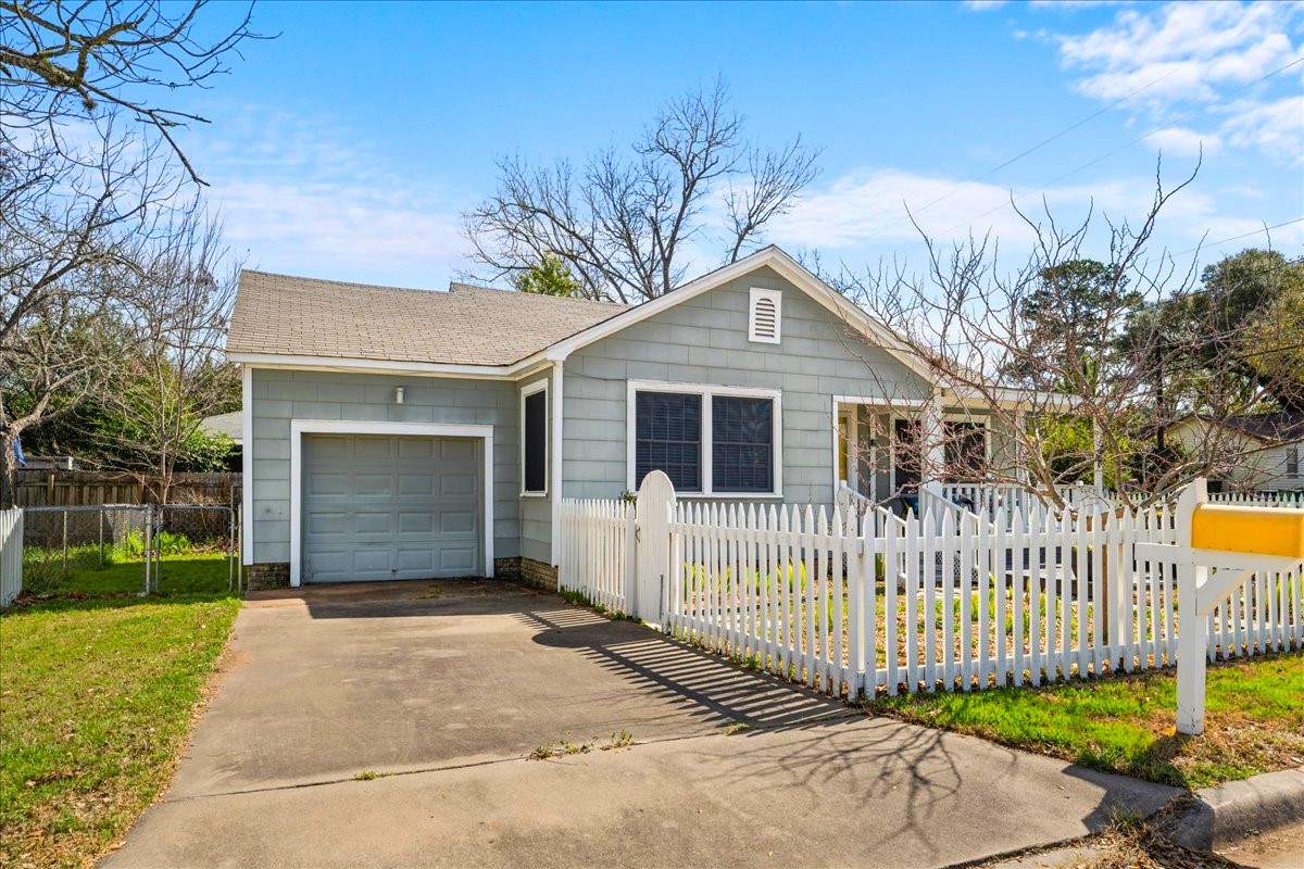 1107 Washington Street Brenham, TX 77833 - Photo 4 of 19 a front view of a house with a garden and plants