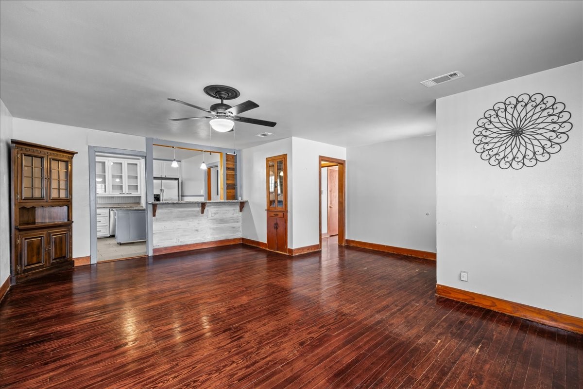 1107 Washington Street Brenham, TX 77833 - Photo 8 of 19 a view of an empty room with wooden floor and a window