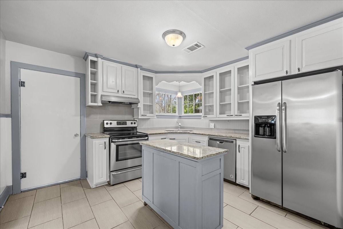 1107 Washington Street Brenham, TX 77833 - Photo 9 of 19 a kitchen with stainless steel appliances granite countertop a stove a refrigerator and a sink
