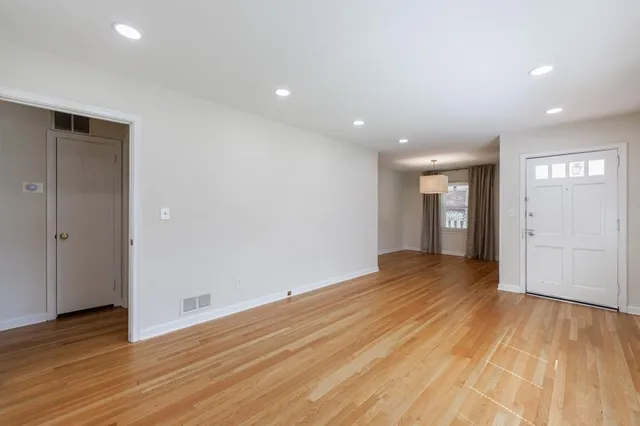 a view of empty room with wooden floor and entryway