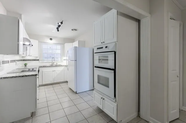 a kitchen with white cabinets and white appliances