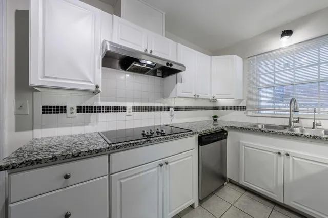 a kitchen with white cabinets and appliances