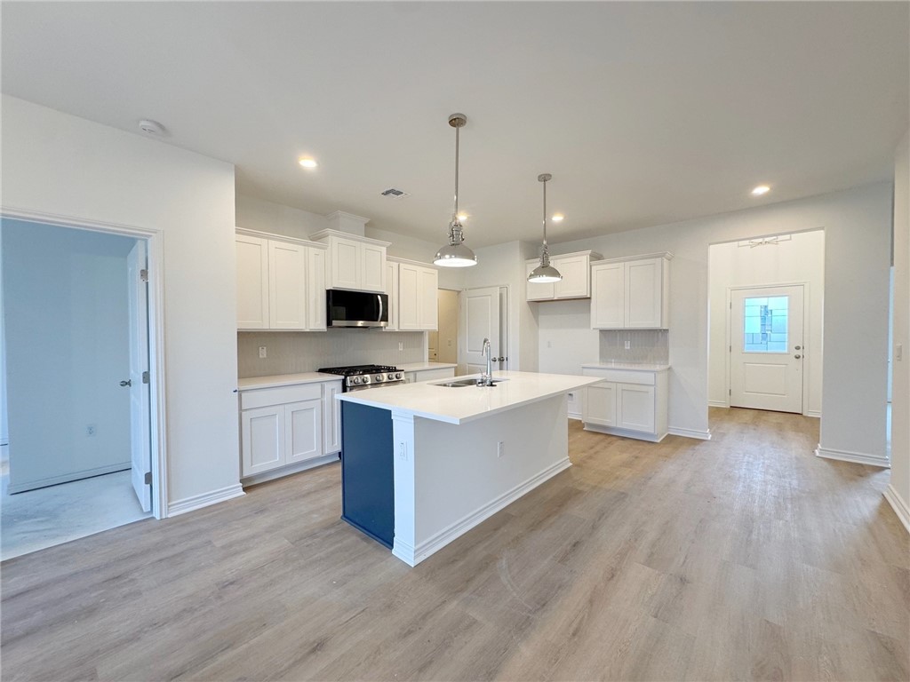 2105 Fury Portland, TX 78374 - Photo 5 of 19 a large kitchen with kitchen island a white counter space a sink stainless steel appliances and cabinets