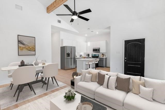 5306 Ridgeway Drive, Unit A Houston, TX 77033 - Photo 4 of 7 Virtually staged to illustrate design potential, this bright open-concept living and dining area showcases soaring ceilings, exposed wood beam accents, abundant natural light, and seamless flow into the kitchen.