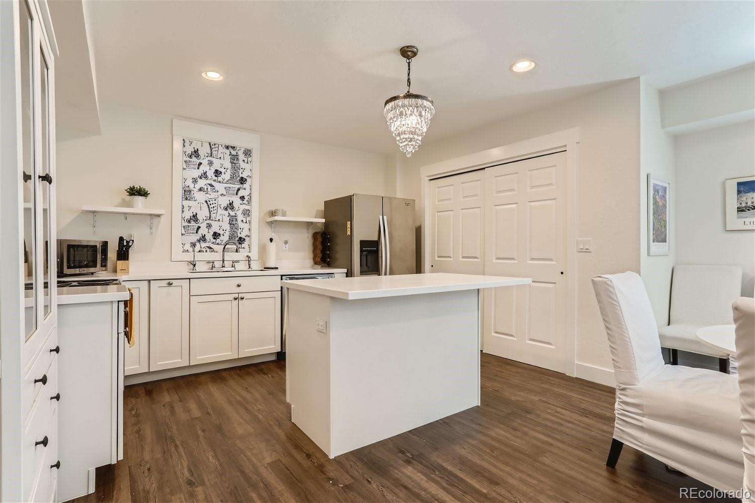 6650 Crestbrook Drive Morrison, CO 80465 - Photo 22 of 38 a kitchen with white cabinets and wooden floor