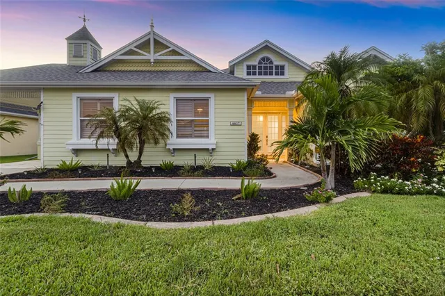 an empty room with chandelier fan and windows