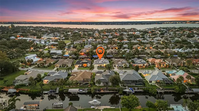 a view of an empty room with wooden floor and a ceiling fan