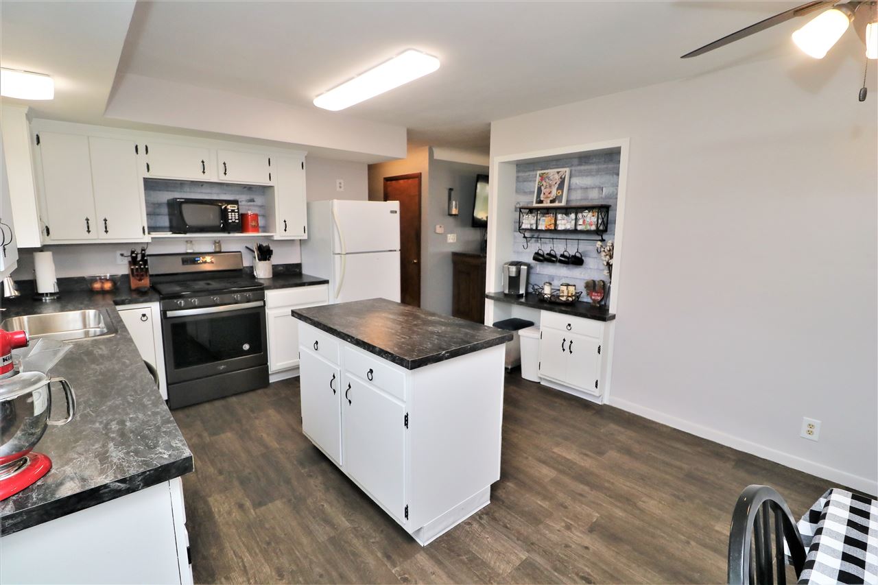 16127 Edwardsville Road Pecatonica, IL 61063 - Photo 9 of 26 a kitchen with stainless steel appliances granite countertop a stove top oven a sink and dishwasher