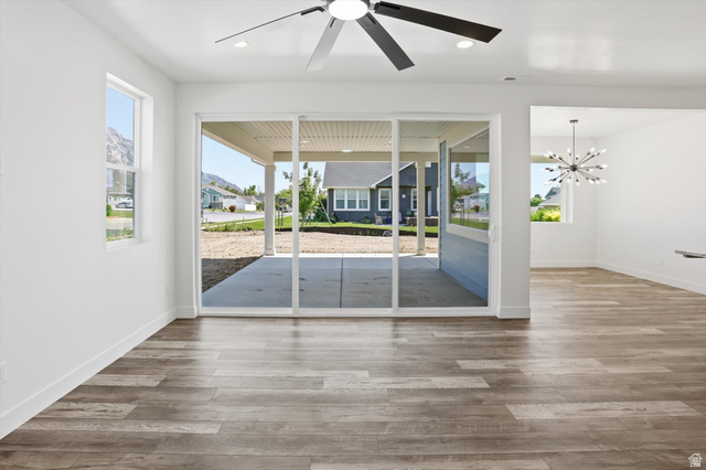 1315 West 3200 South, Unit 17 Perry, UT 84302 - Photo 11 of 58 Spacious open-concept room featuring wood-finish flooring, a contemporary ceiling fan, and abundant natural light from a large window