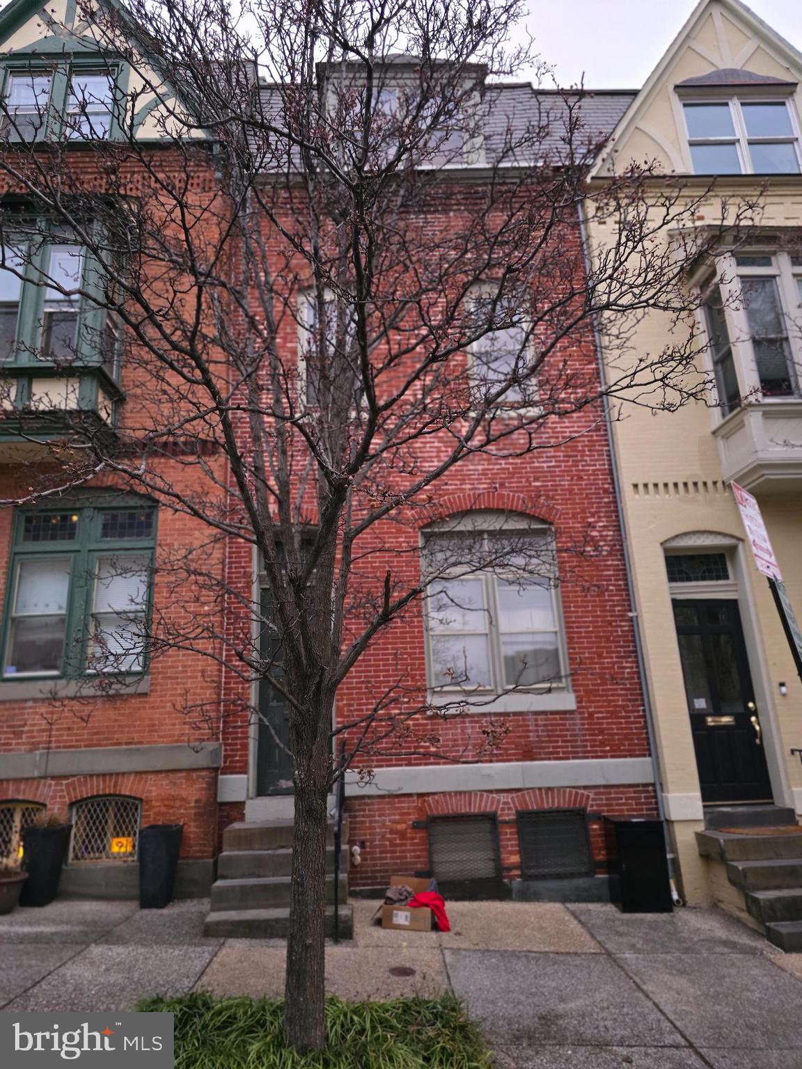 1205 John Street Baltimore, MD 21217 - Photo 1 of 2 a red brick building with trees in front of it