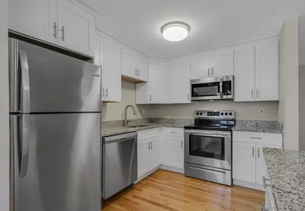 a kitchen with stainless steel appliances granite countertop a refrigerator stove a sink and a microwave