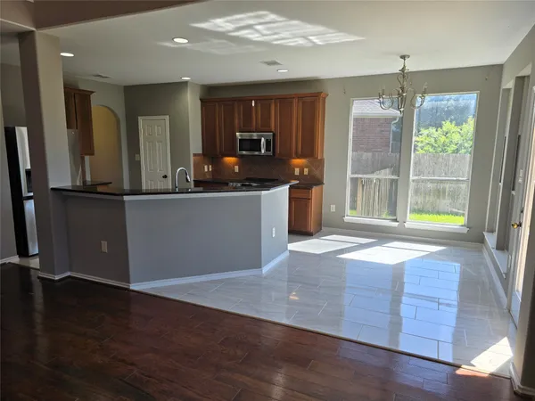 a kitchen with stainless steel appliances granite countertop a refrigerator a stove and a wooden floors