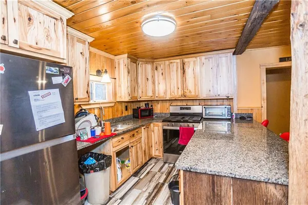 a kitchen with stainless steel appliances granite countertop a sink dishwasher and cabinets with wooden floor