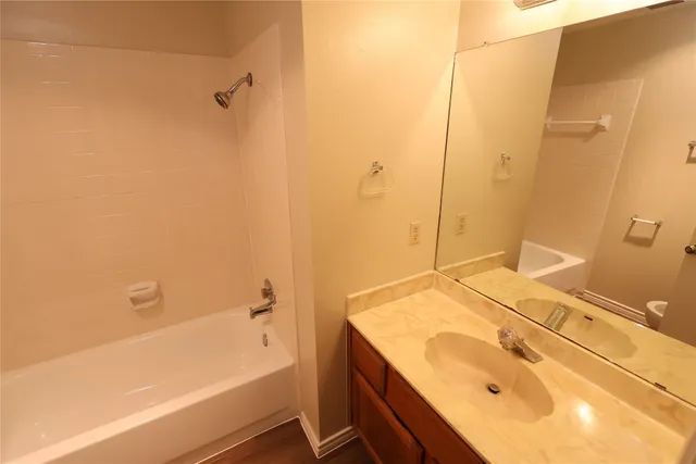 a bathroom with a granite countertop sink and a bathtub