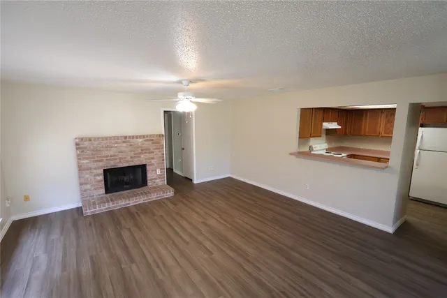 a view of empty room with wooden floor and fireplace