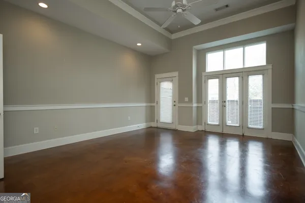 an empty room with wooden floor and windows