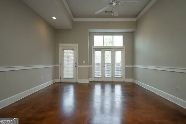 an empty room with wooden floor and windows