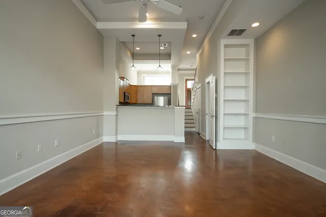 wooden floor in an empty room with a kitchen