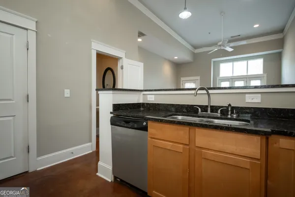 a kitchen with granite countertop a sink and a stove top oven