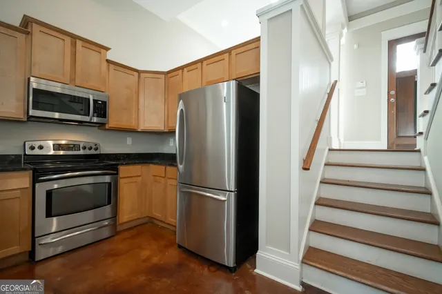 a kitchen with stainless steel appliances granite countertop a stove a sink and a microwave