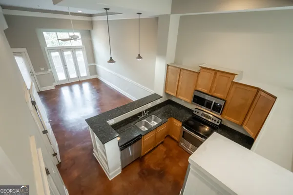 a view of an empty room with wooden floor and windows
