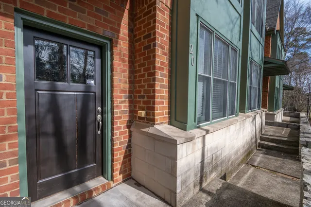 a view of a brick house with a wooden bench