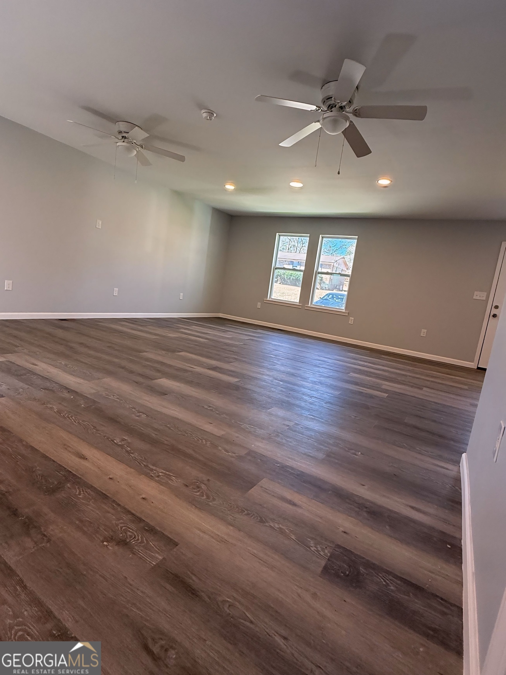 24 George Street Forsyth, GA 31029 - Photo 4 of 20 an empty room with wooden floor fan and windows