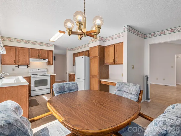 a living room with stainless steel appliances kitchen island granite countertop furniture and a wooden floor