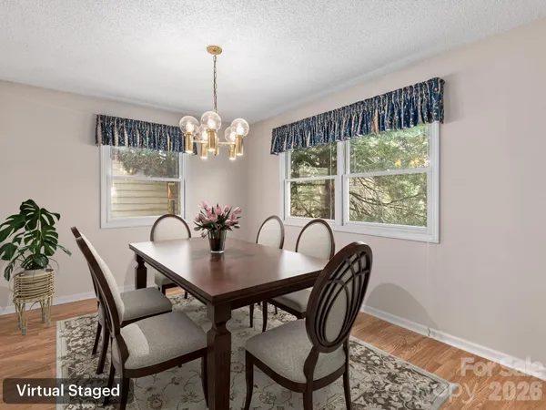 a dining room with furniture a chandelier and wooden floor