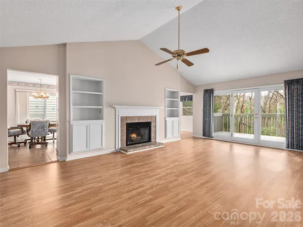 a view of empty room with wooden floor and fireplace