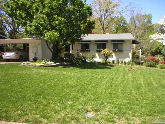 a front view of a house with a garden and trees
