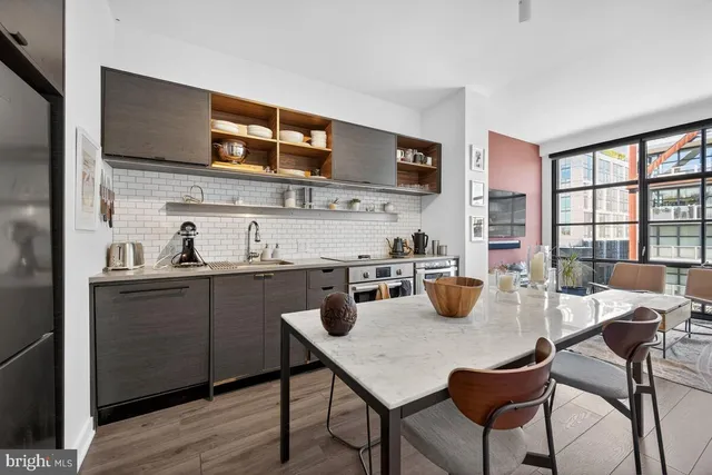 a kitchen with a dining table chairs and wooden floor