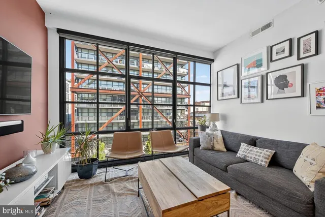 a living room with furniture and floor to ceiling windows