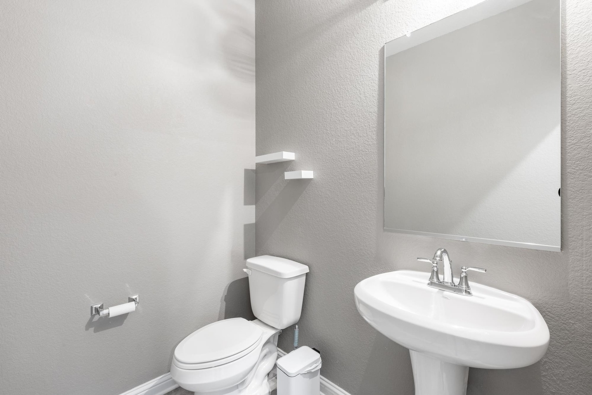 7801 Frida Bend Austin, TX 78744 - Photo 15 of 26 A well-appointed lavatory offers essential facilities with a sleek, space-saving pedestal sink.