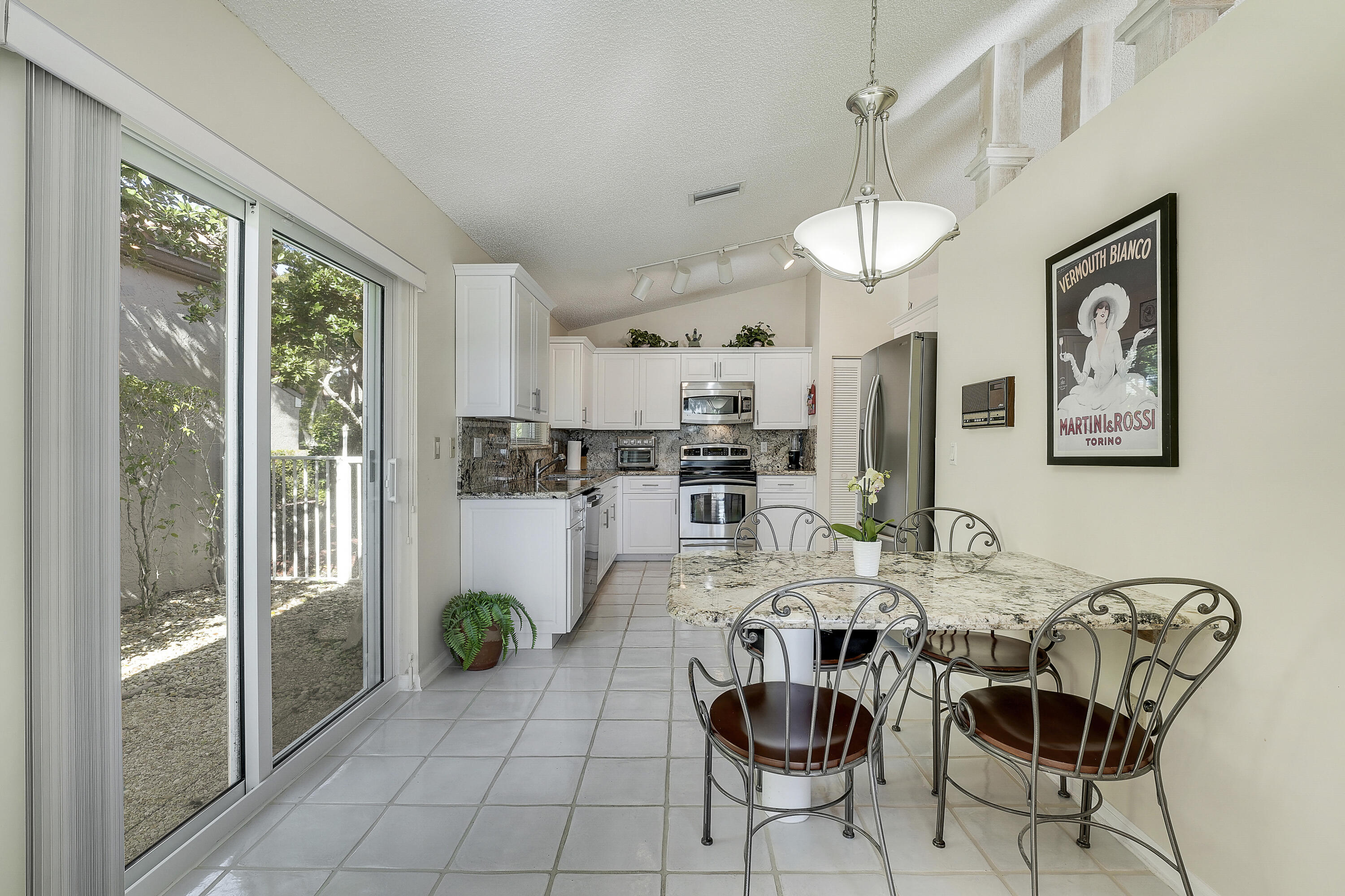 7283 Via Palomar Boca Raton, FL 33433 - Photo 17 of 43 a view of a dining room with furniture a kitchen and chandelier
