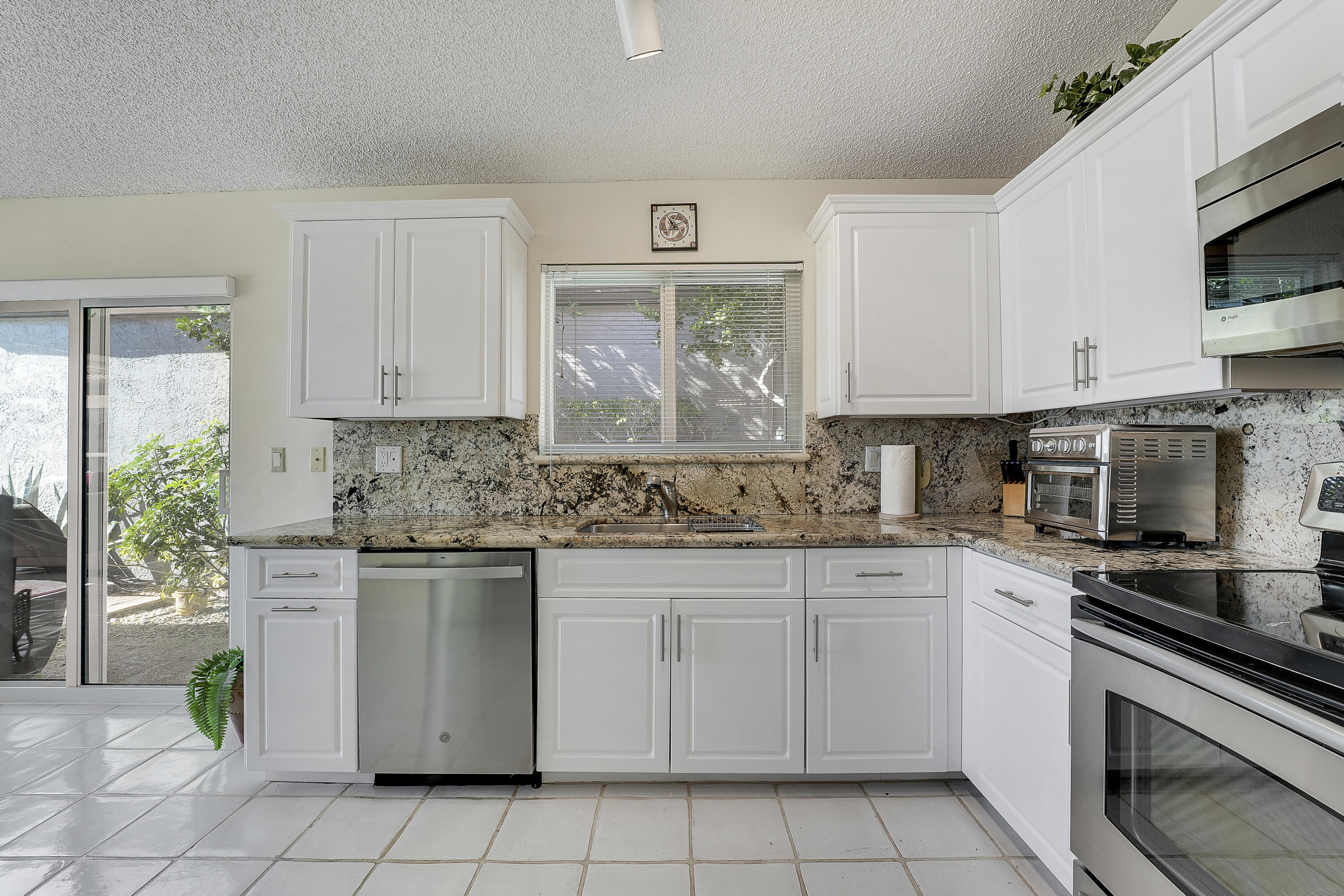 7283 Via Palomar Boca Raton, FL 33433 - Photo 19 of 43 a kitchen with white cabinets stainless steel appliances and a sink