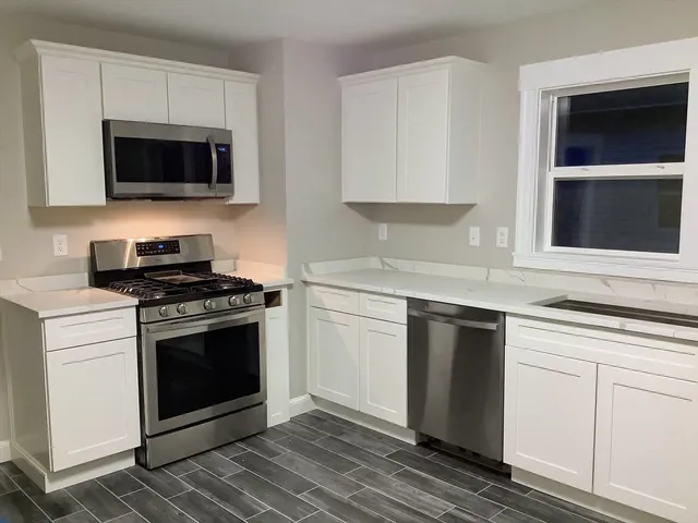 a kitchen with granite countertop a stove and a microwave