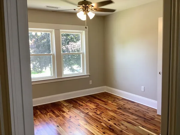 a view of a room with wooden floor and natural light