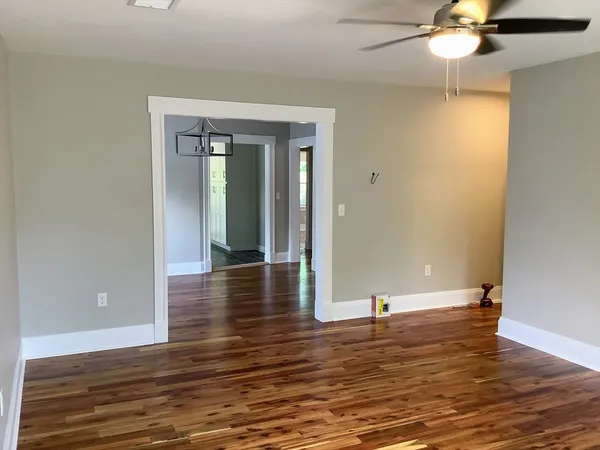 a view of a livingroom with wooden floor and a ceiling fan