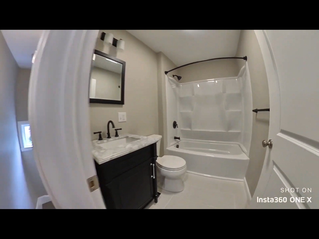 101-103 Lexington Street Newton, MA 02466 - Photo 23 of 37 a bathroom with a sink a toilet a mirror and bathtub