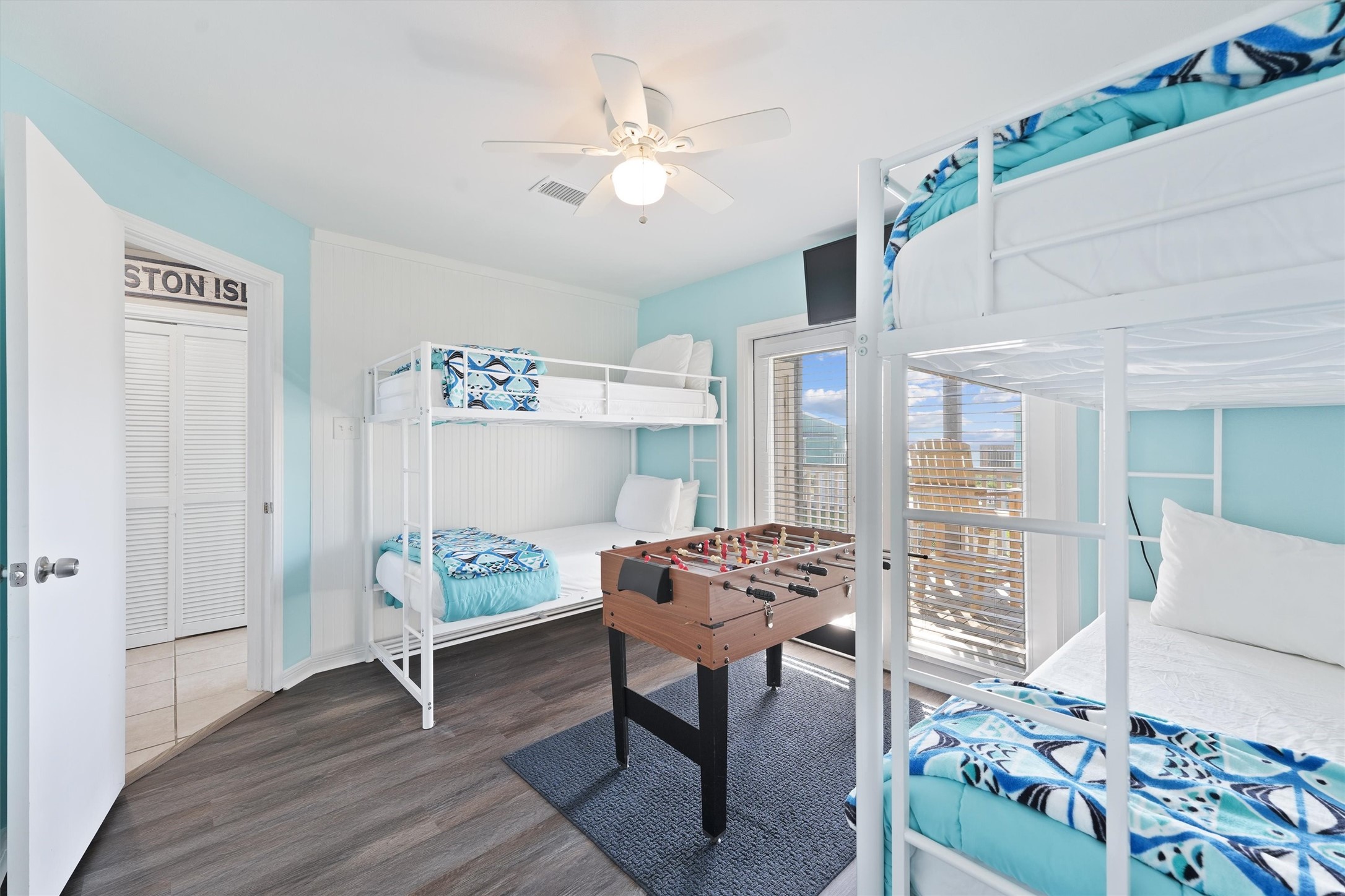 17607 Termini-San Luis Pass Road Galveston, TX 77554 - Photo 28 of 42 The second bedroom is bright and inviting, with soft blue walls that create a relaxing atmosphere. The foosball table serves as a playful centerpiece for guests to enjoy.