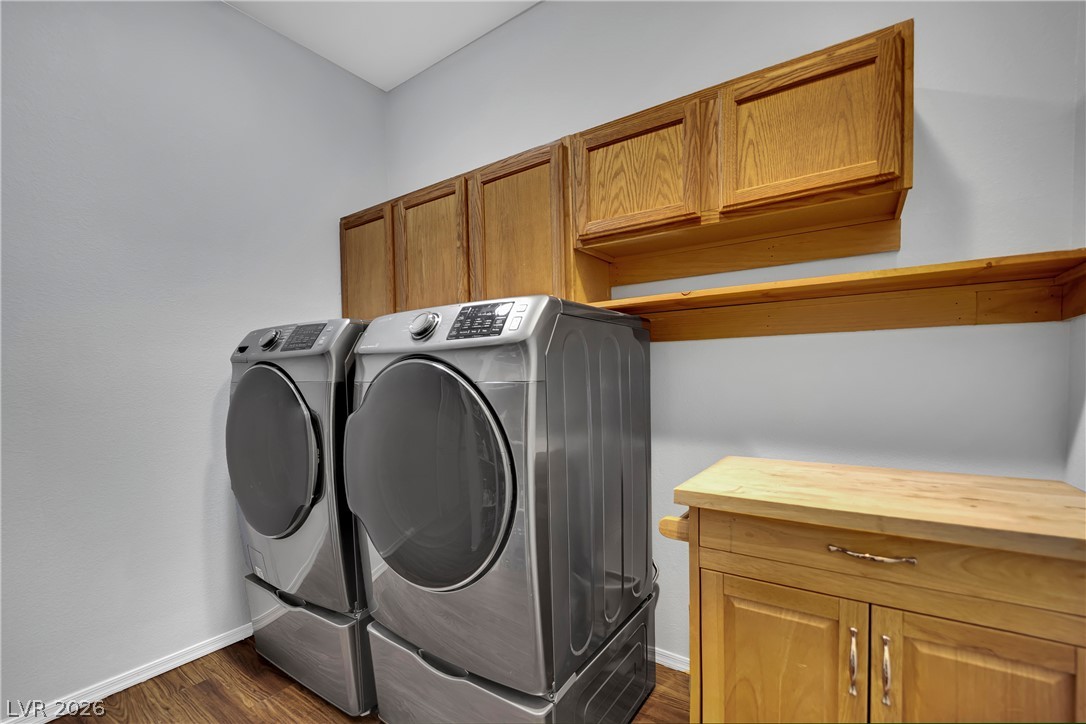 1724 Millstream Way Henderson, NV 89074 - Photo 22 of 60 Functional laundry room featuring rich wood cabinetry and convenient appliance access for daily tasks.