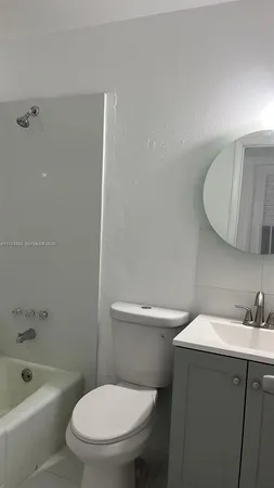 a white toilet sitting next to a bath tub