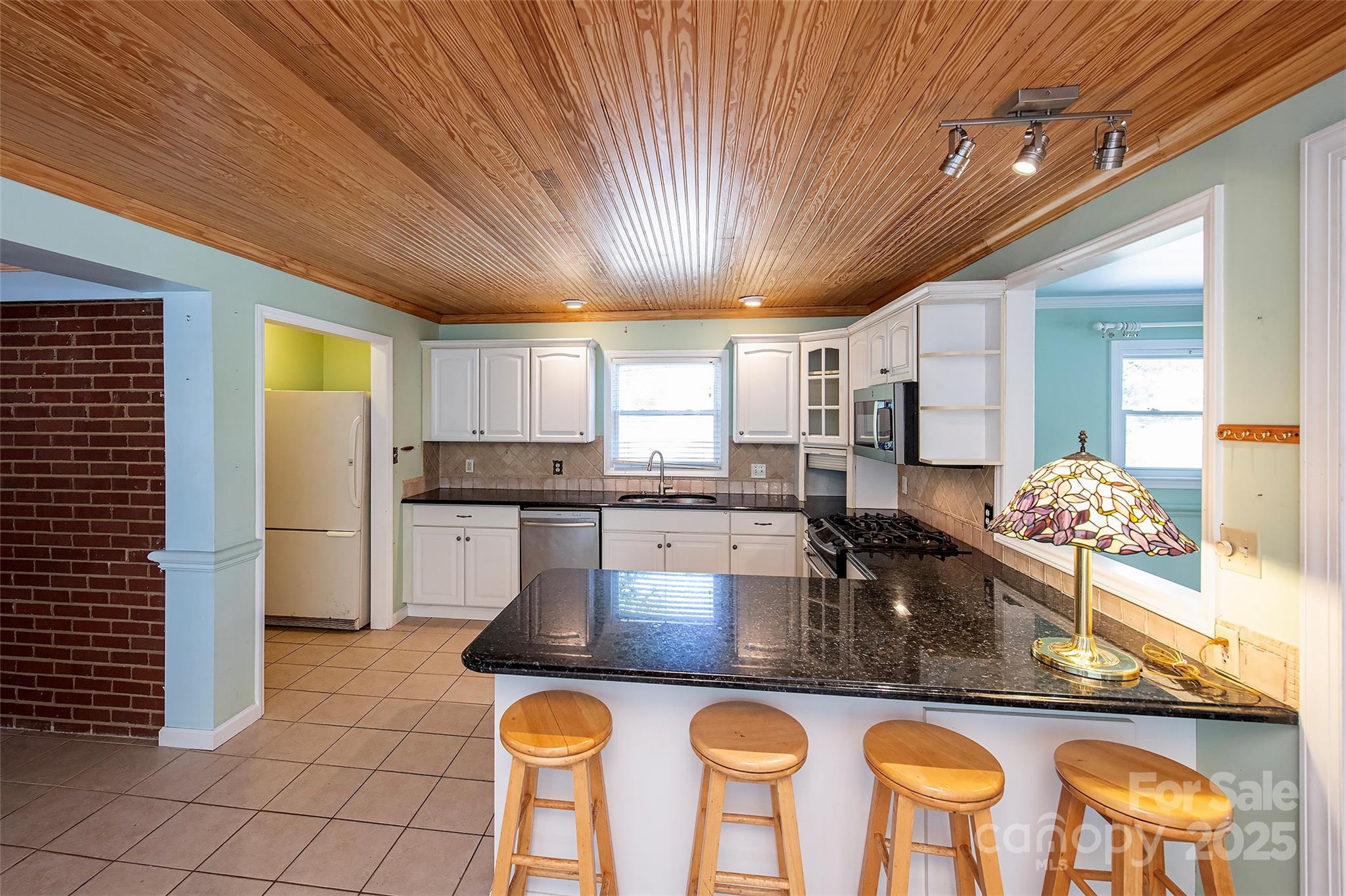 6332 Montpelier Road Charlotte, NC 28210 - Photo 13 of 30 a kitchen with stainless steel appliances granite countertop a stove a refrigerator a oven with white cabinets and couches