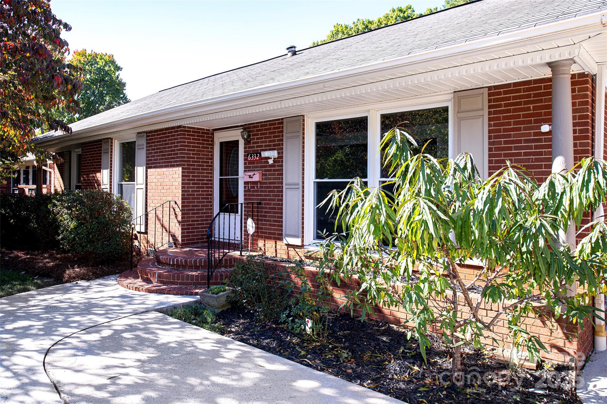6332 Montpelier Road Charlotte, NC 28210 - Photo 2 of 30 a view of a house with potted plants and a bench